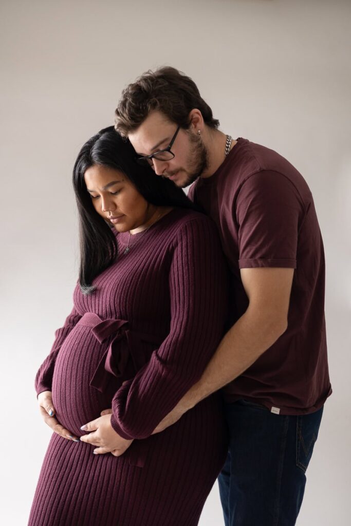 Gravid med partner i matchande vinröda kläder